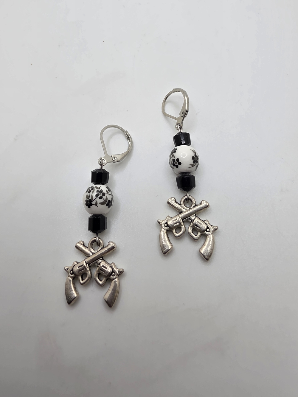 Black and White Floral Bead Earrings with Crossed Gun Charms